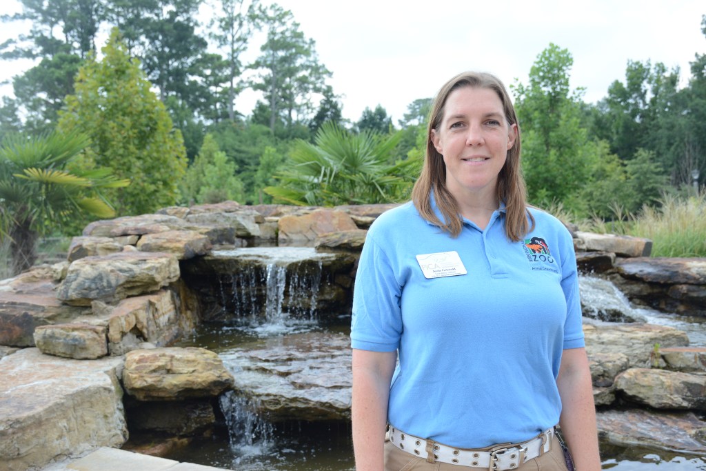 Jessie Griswold stands in front of the waterfall at the Birmingham Zoo entrance.