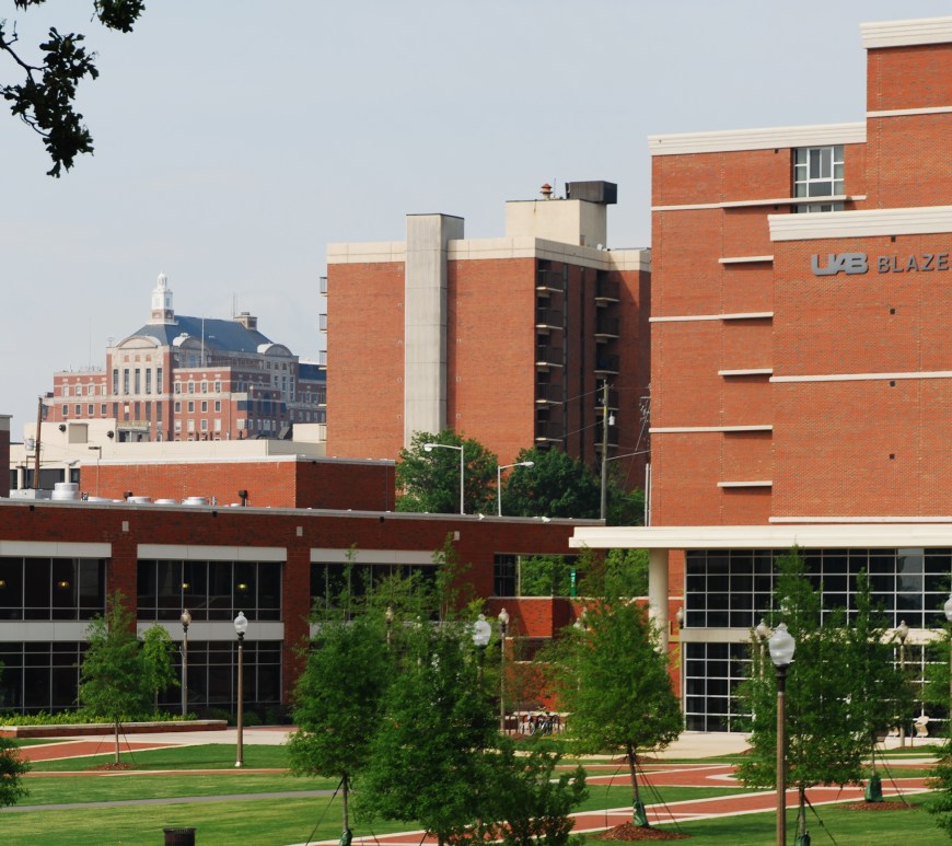 A large red-brick building on the UAB campus, with a small green area in front of it.