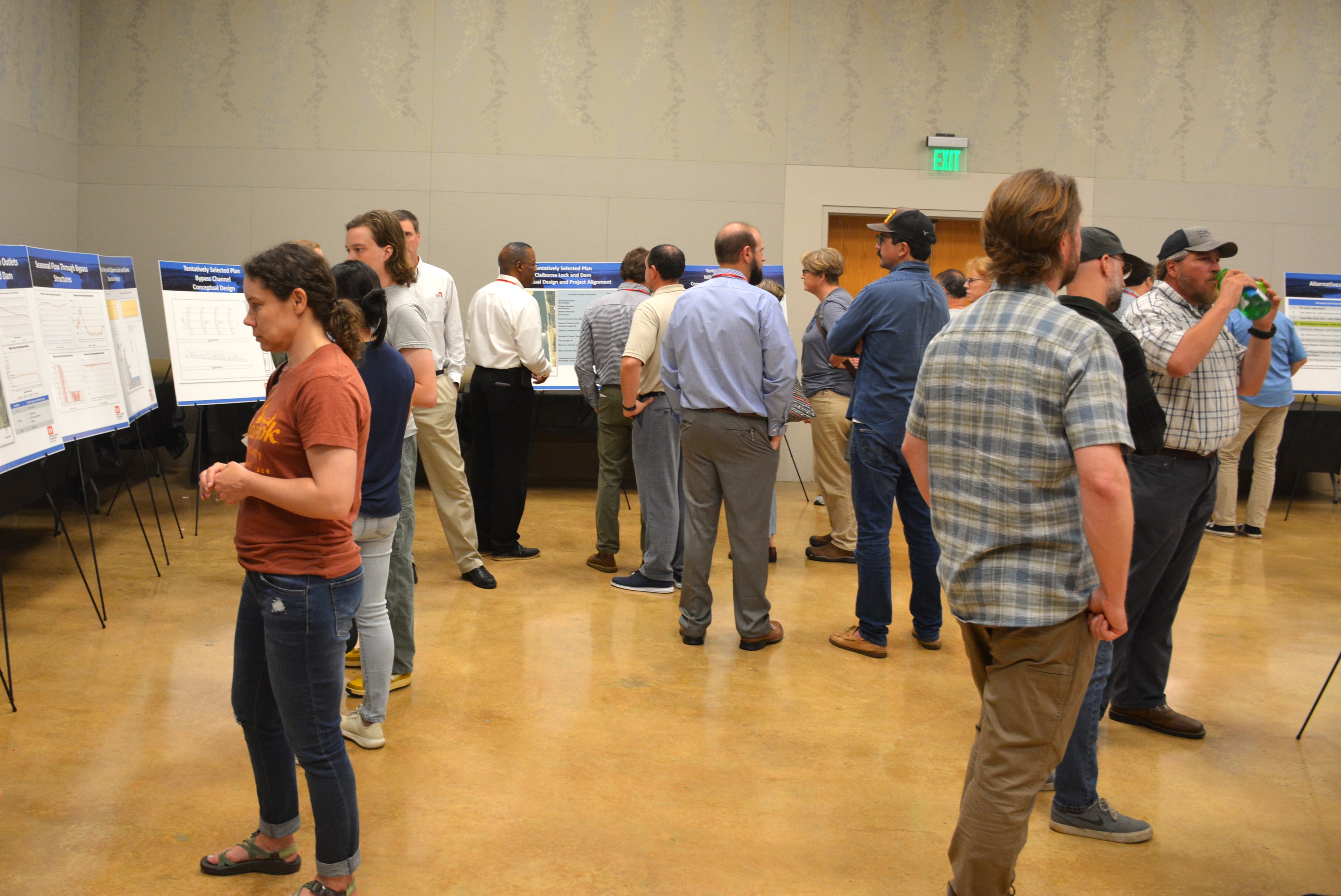 A meeting room is ringed with easels holding posterboards that describe various aspects of the fish passage project. People mill about the room to look at the boards and discuss with Army Corps of Engineers staff.