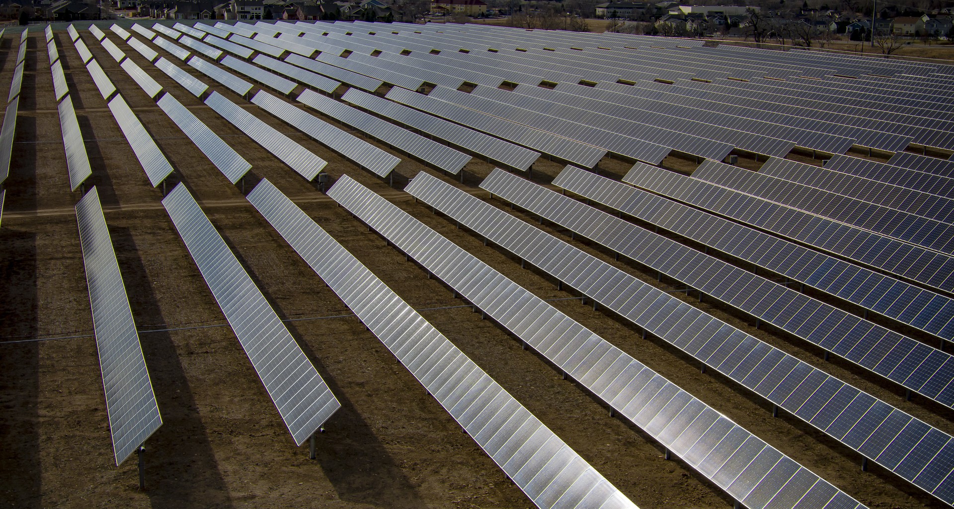 Rows of solar panels facing the left side of the image and stretching to the horizon.