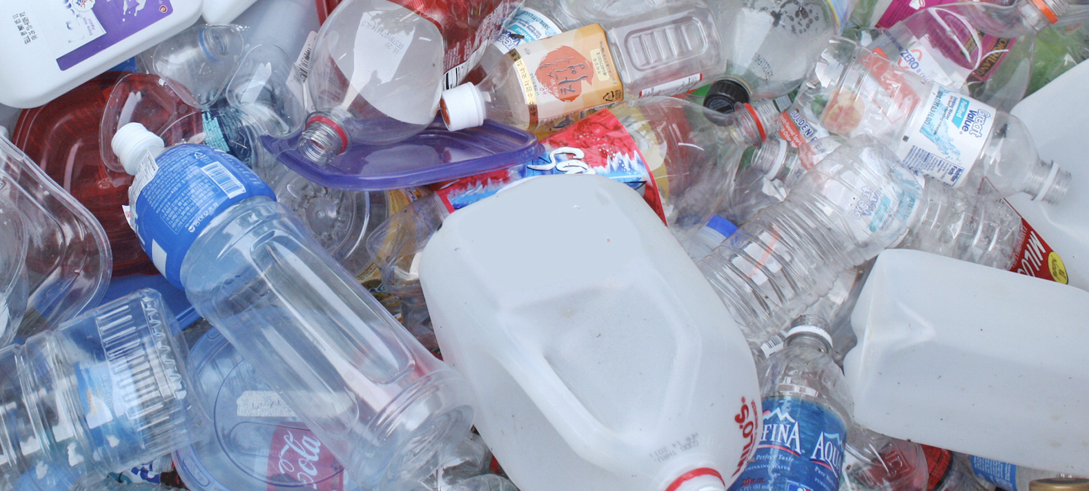 A pile of plastic bottles, milk jugs and other plastic waste.