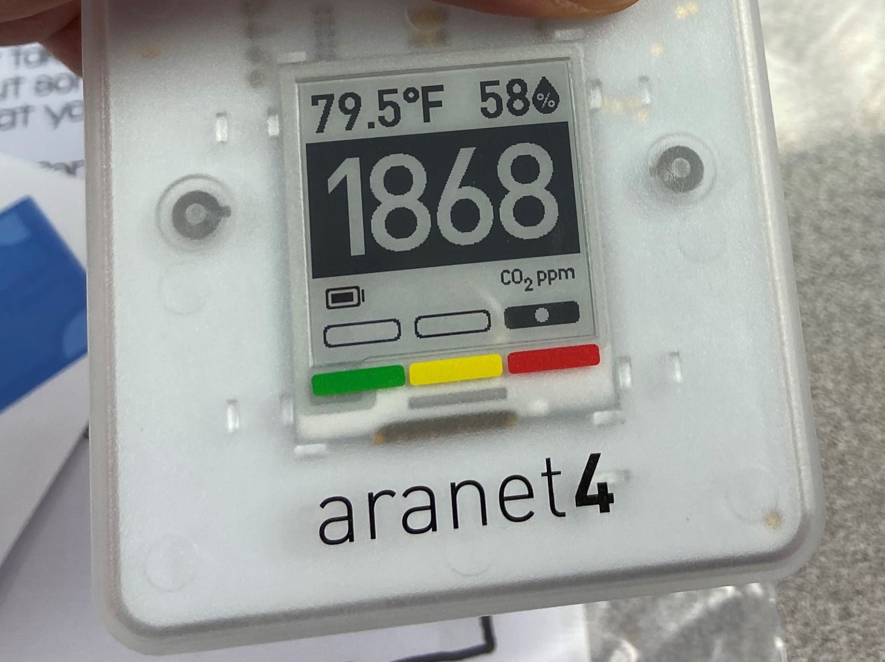 A close-up of a CO2 monitor readout showing the air temperature (79.5 F), humidity (58%) and CO2 concentration (1,868 ppm). The monitor is branded Aranet4.